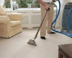 Carpet cleaning professional removing dirt and stains with a hot-water extraction tool in a home, Scottsdale, AZ.