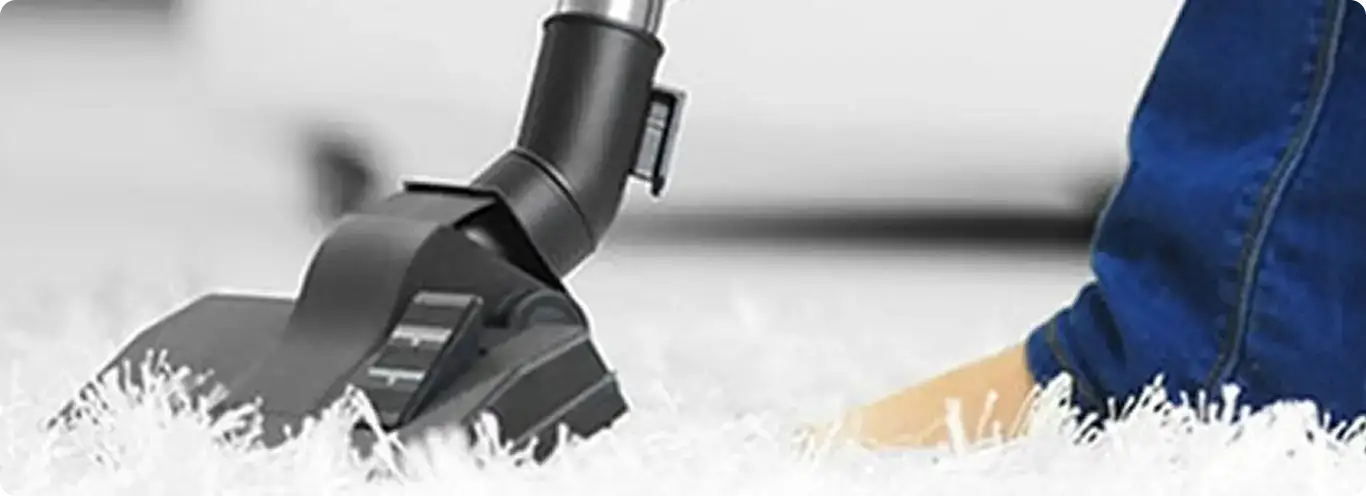 Close-up of a professional vacuuming a white carpet in Chandler.