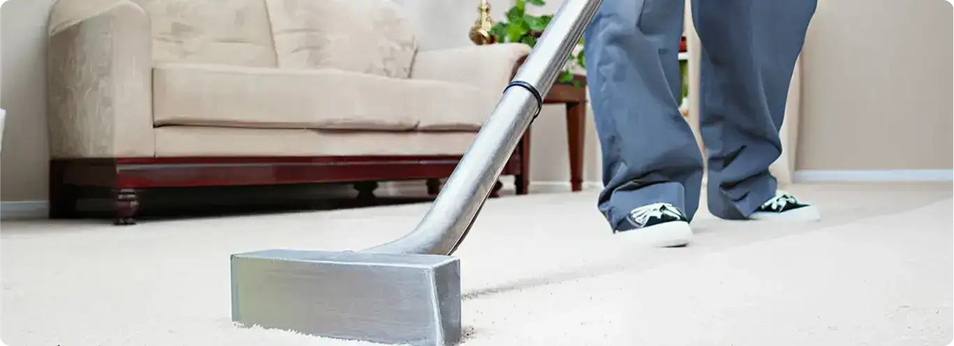 Carpet cleaning technician using a hot-water extraction wand on a light-colored carpet in a living room, Scottsdale, AZ.