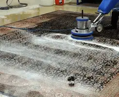 Professional rug cleaning with a rotary floor machine and shampoo foam, deep-cleaning an area rug, in Scottsdale, AZ.